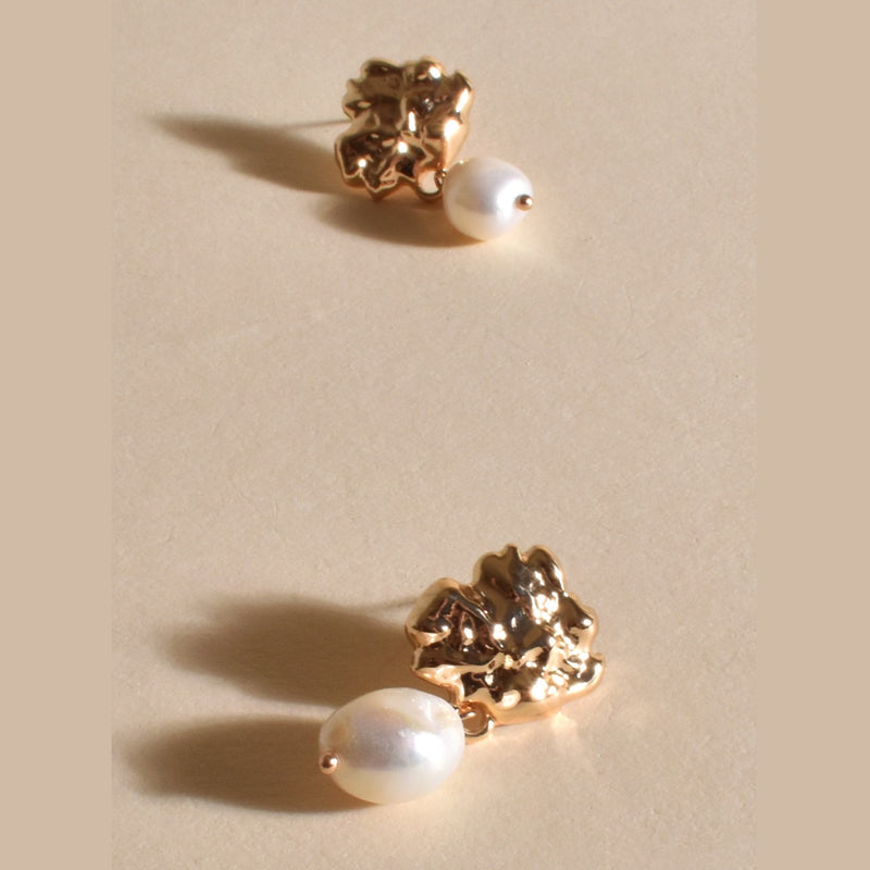 These earrings have a organic shaped gold top with a freshwater pearl drop and stud closure
