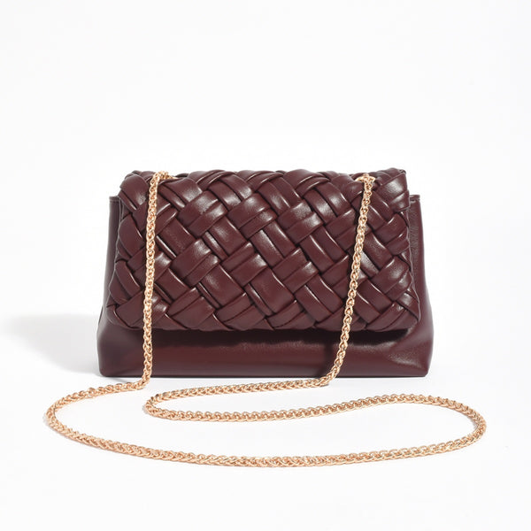 This woven handbag has a gold chain shoulder strap.