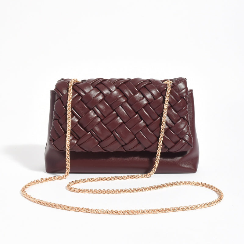 This woven handbag has a gold chain shoulder strap.