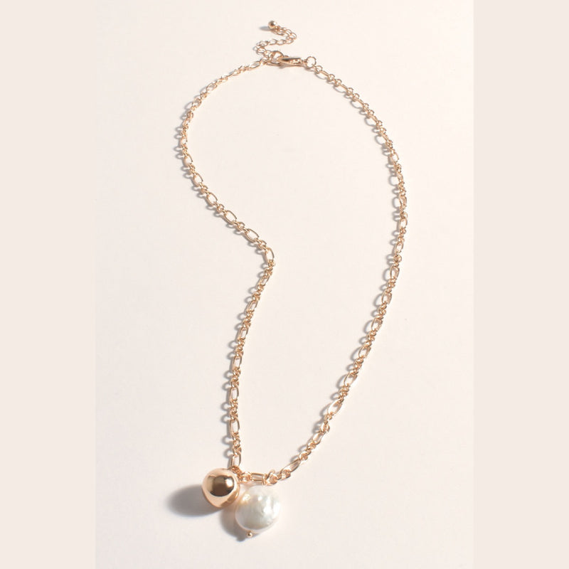 This gold necklace has a single pearl and gold ball suspended from the chain