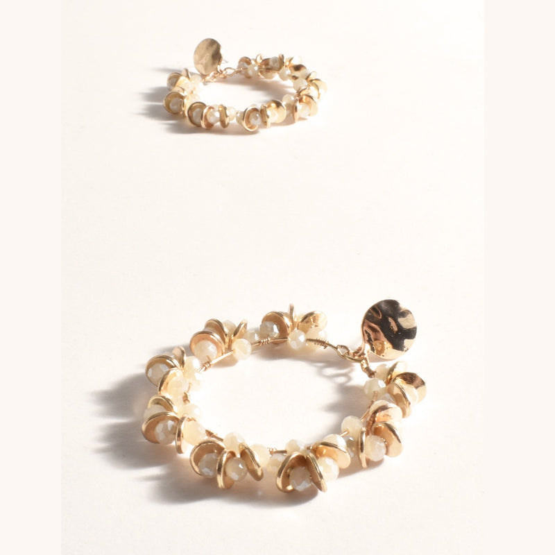 These earrings have cream coloured beads, gold metal discs and a gold textured stud.