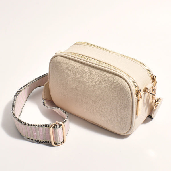 Bella Crossbody Camera Bag in Beige with a pink, beige and black stripe webbed shoulder strap