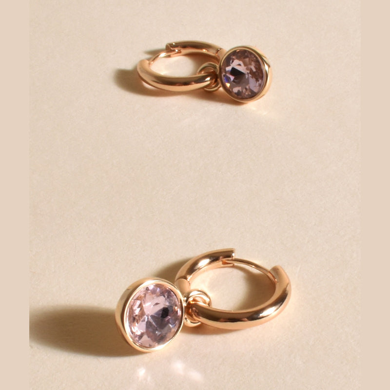 Bella Jewel Drop Earrings in Pink and Gold.  These hoop earrings have a round pink jewel suspended from the hoop.