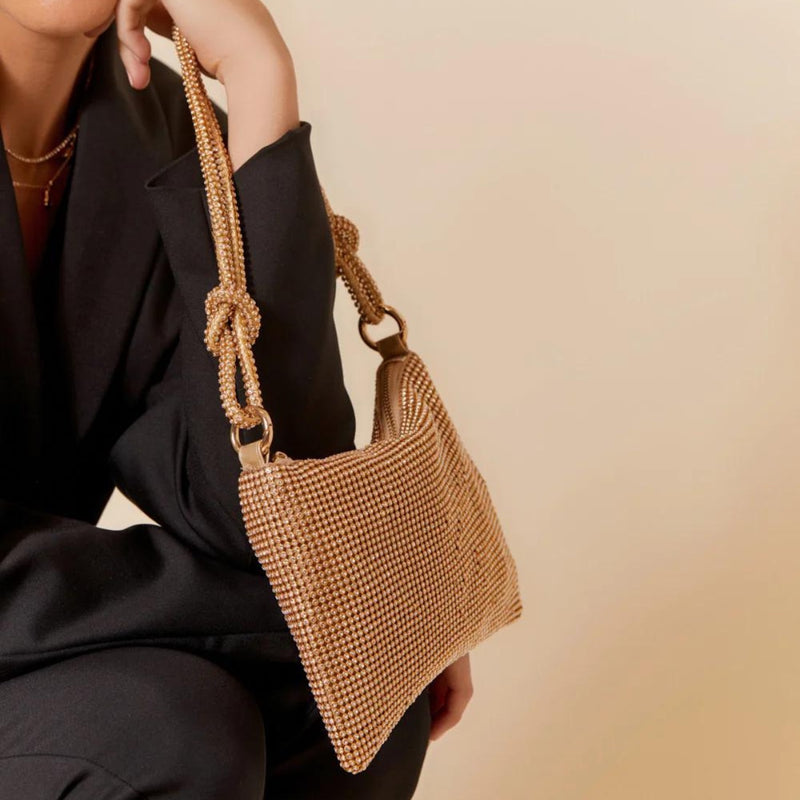 This gold evening bag is made from a diamante mesh material and it has knot detail on the shoulder straps