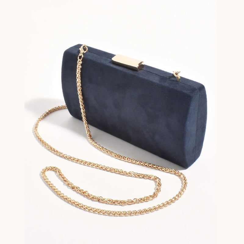This slimline navy clutch has a gold clasp closure, detachable gold chain shoulder strap.