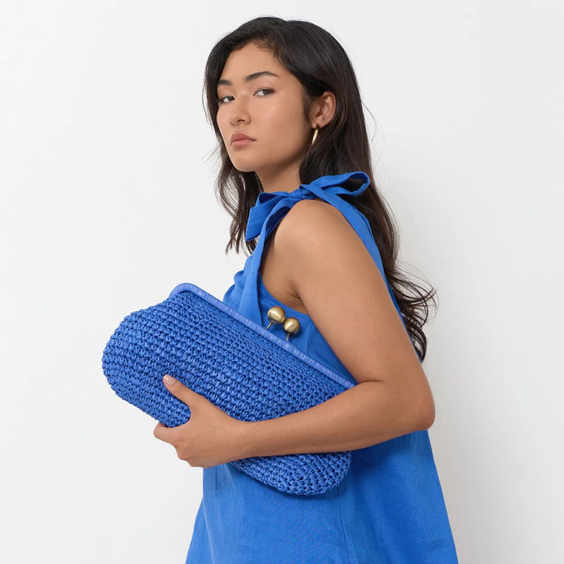 Model carrying the Clip Top Elongated Weave Clutch (Cobalt)