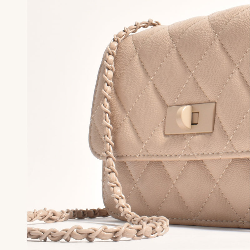 This quilted bag has a nude coloured chain strap and metal clasp closure