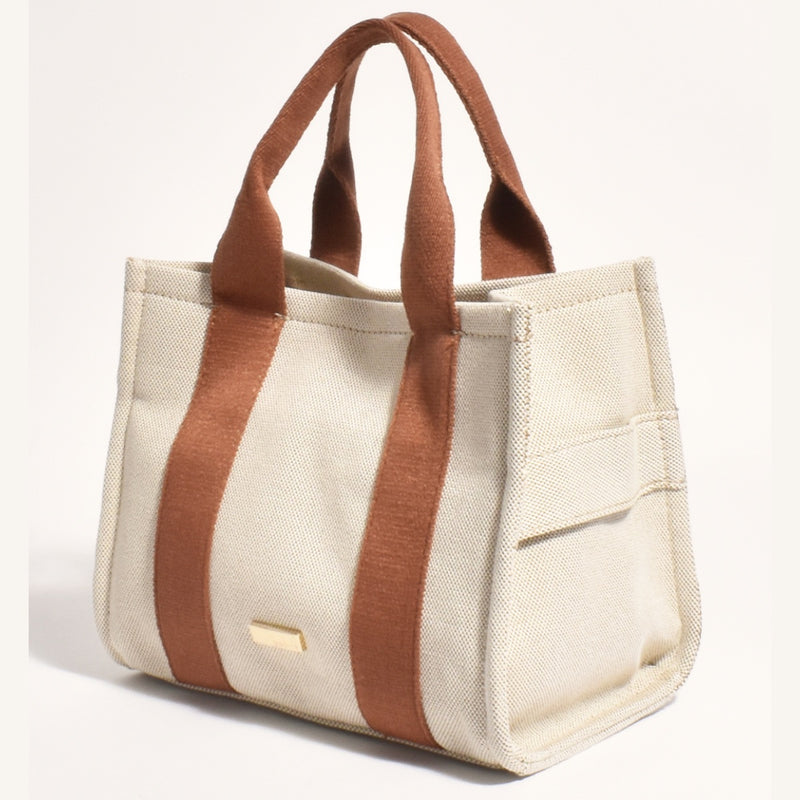 This tote bag has tan coloured straps and can also be used as a shoulder bag