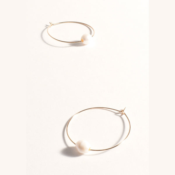 These gold hoop earrings have a single freshwater pearl drop.