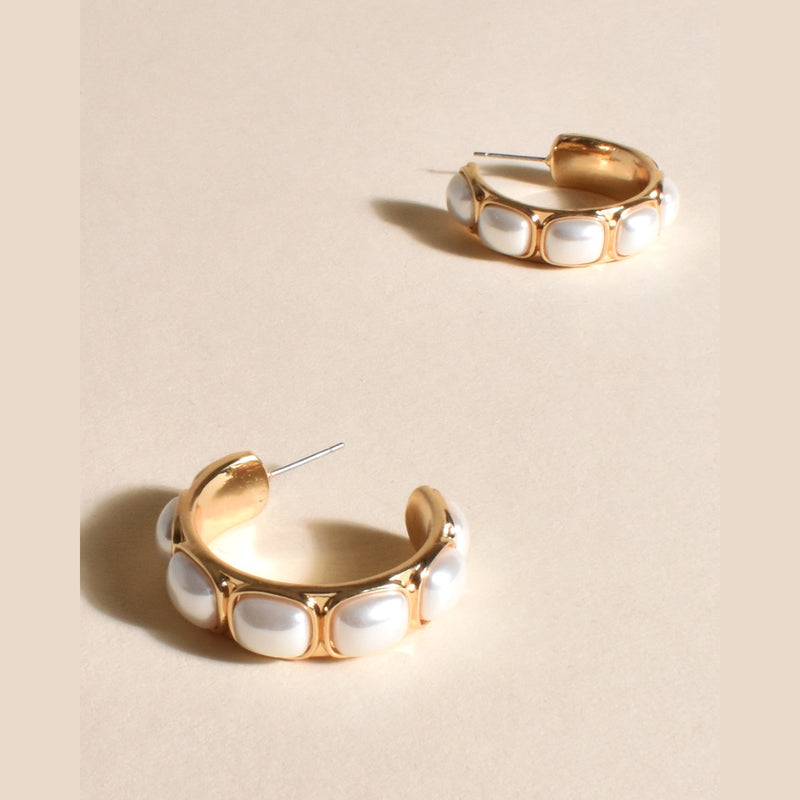 These gold hoop earrings have faux pearl detail throughout and a stud closure