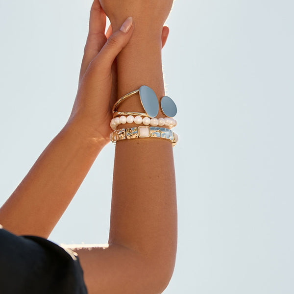 Model wearing a stack of bracelets including the Inset Stone Stretch Bracelet