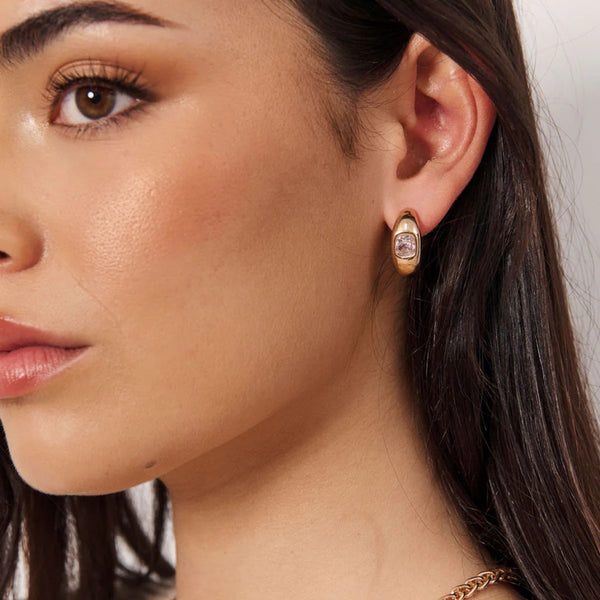 Model wearing these gold earrings.