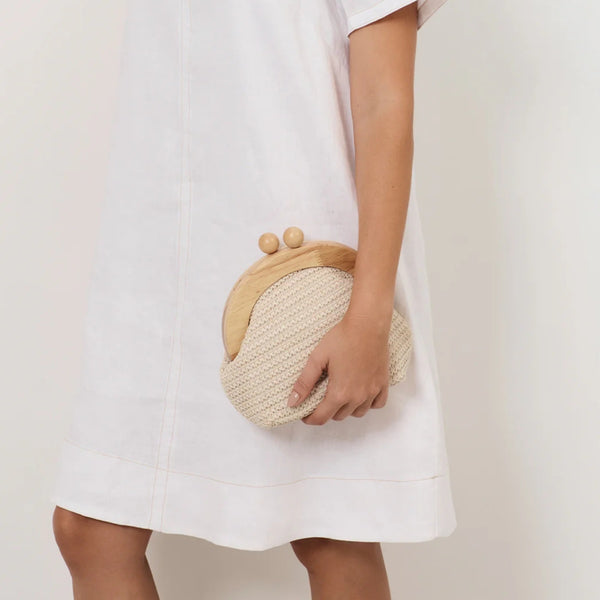 Model carrying our Light Weave Curved Timber Frame Clutch (Cream)
