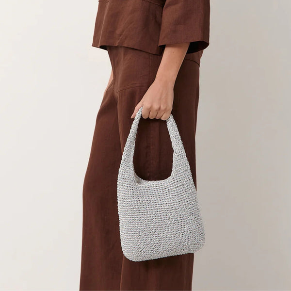 This silver metallic bag has a single top handle and its a perfect size to fit your essentials.
