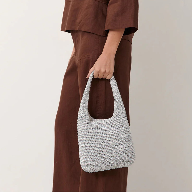 This silver metallic bag has a single top handle and its a perfect size to fit your essentials.