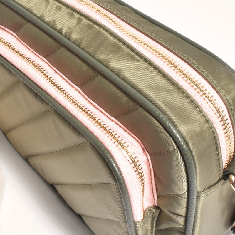 Close up of the quilted material in khaki and the pink zips