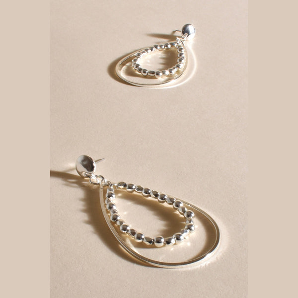 These earrings have a stud closure, teardrop shape with a flat metal and metal ball detail