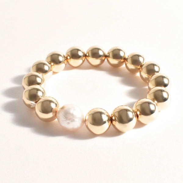 This bracelet features a pearl centre and chunky gold metal balls