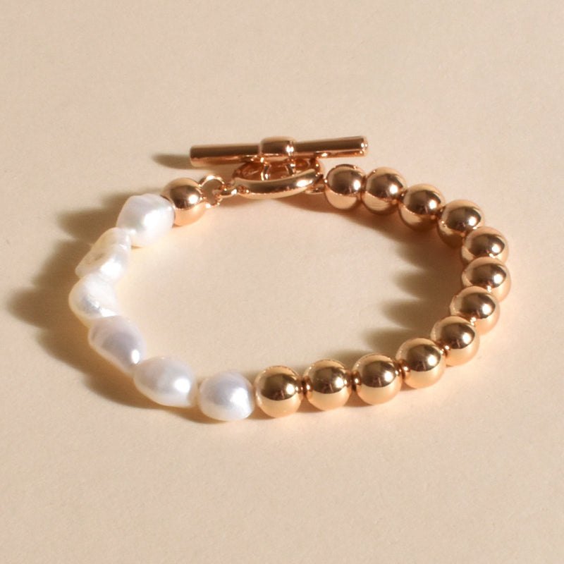 Half Pearl and Metal Ball Bracelet with a toggle closure in gold