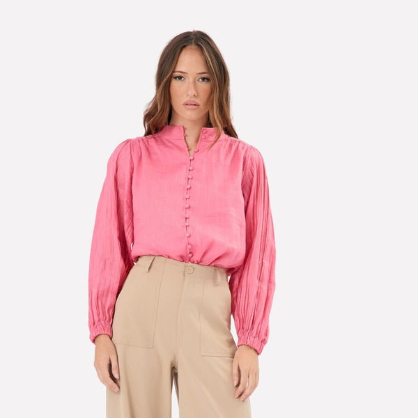 This pink top has a mock collar, button front and long pleated sleeves.