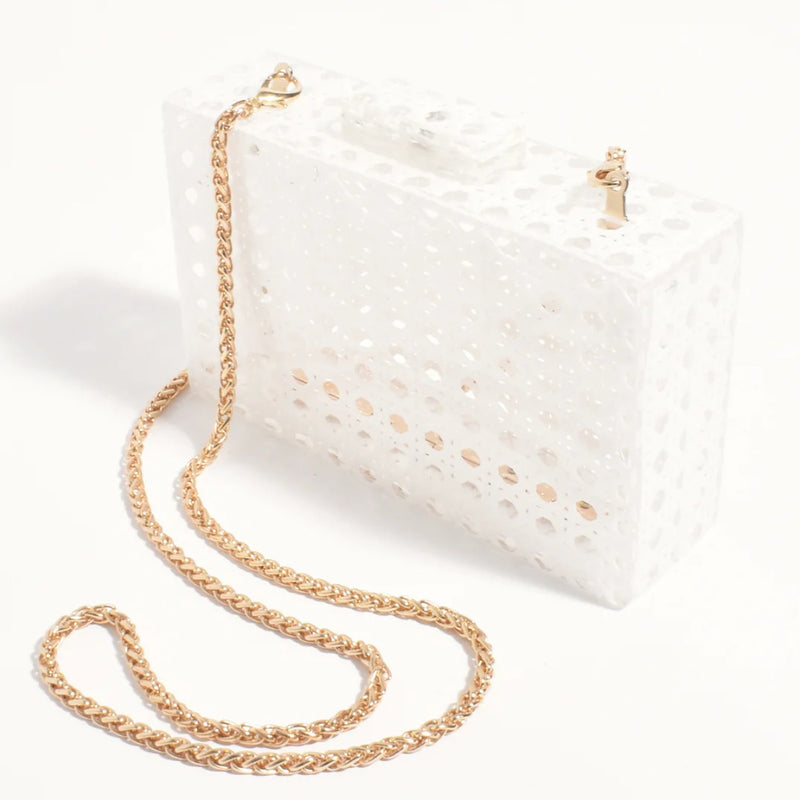 The white clutch has a detachable gold chain shoulder strap