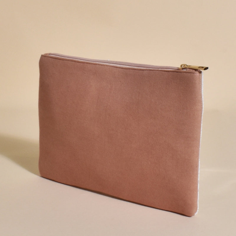 The back of this clutch has a taupe coloured canvas back