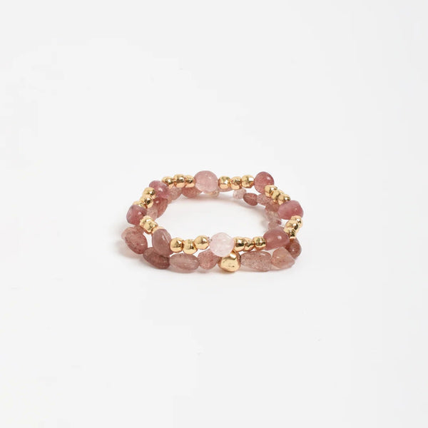 Set includes 2 separate bracelets with pink stones and gold beads.