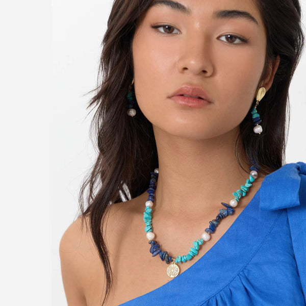 Model wearing the Sun Charm Stone Chip Pearl Necklace in blue.