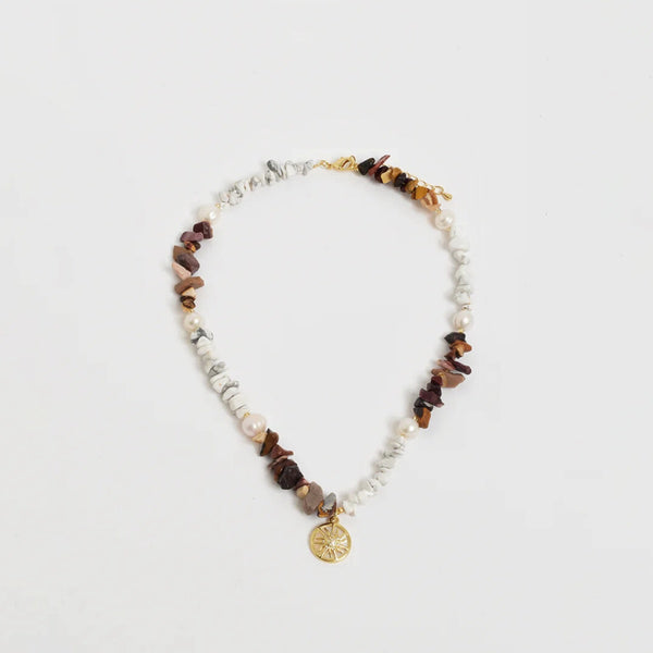 This boho style necklace has an elegant sun charm detail.
