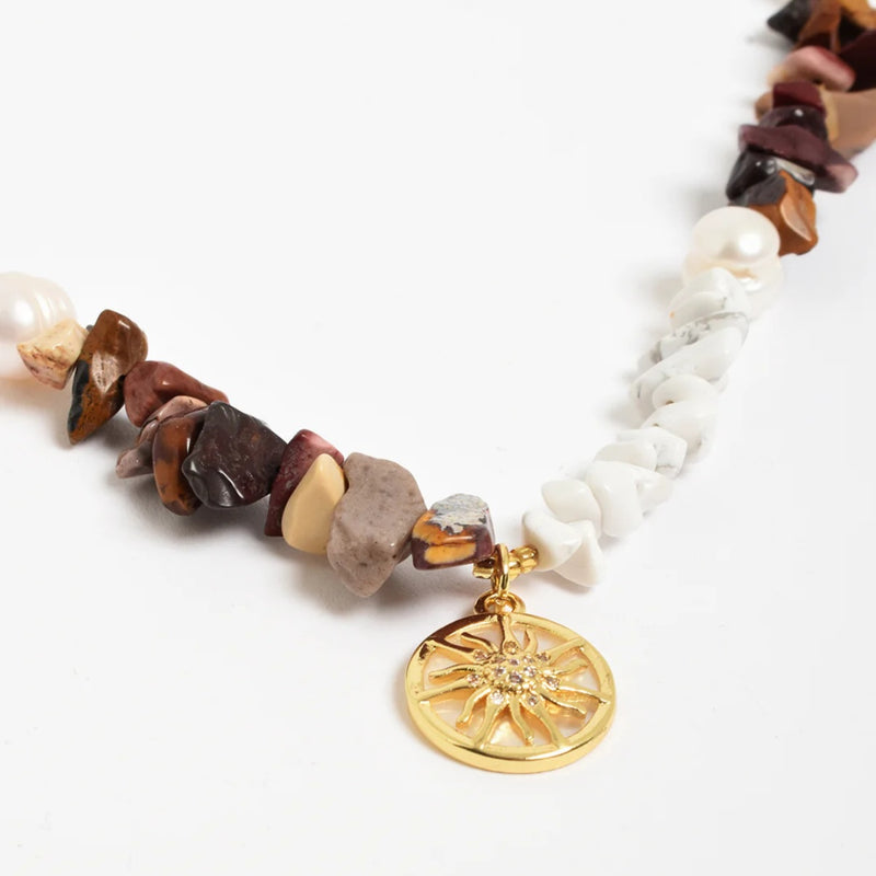 Close up of the gold sun charm.