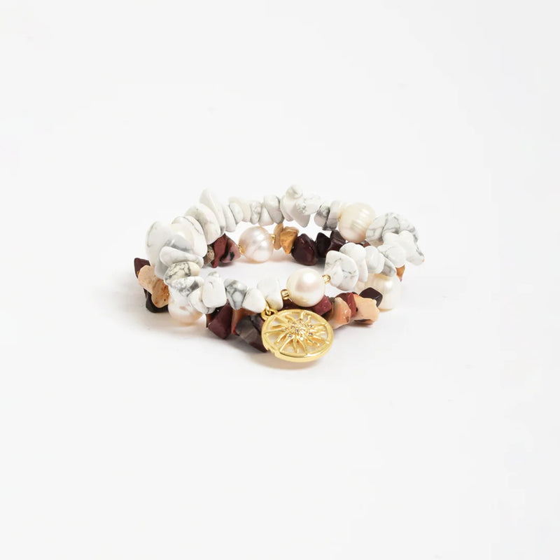 This set includes 2 stretch bracelets affixed together by a gold Sun Charm detail.