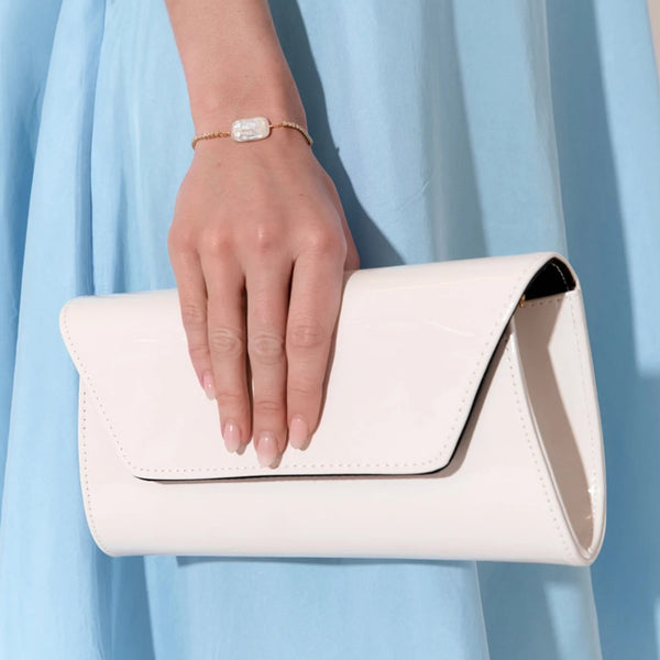 This off-white clutch has a fold over flap closure.