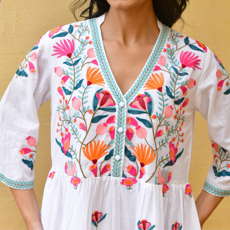Close up of the bodice area and the beautiful embroidery detail with contrast stitching on the neckline, button front and sleeve edge.