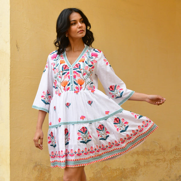 The dress has colourful embroidery throughout and features a V neckline, button bodice, 3/4 length sleeves and a short skirt.
