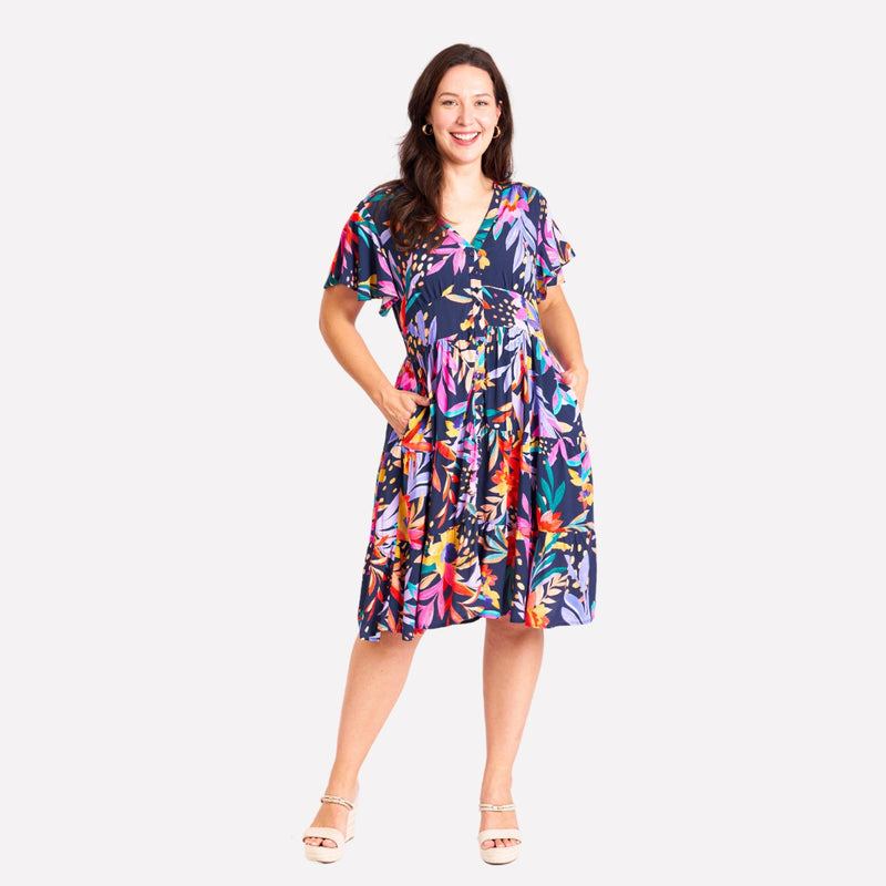 Our Elsa Dress has a bold tropical leaf print in navy, yellow, teal, red and lilac