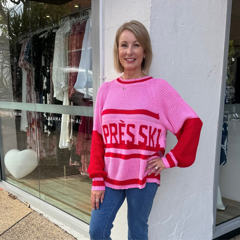 The jumper has pink and red sleeves.