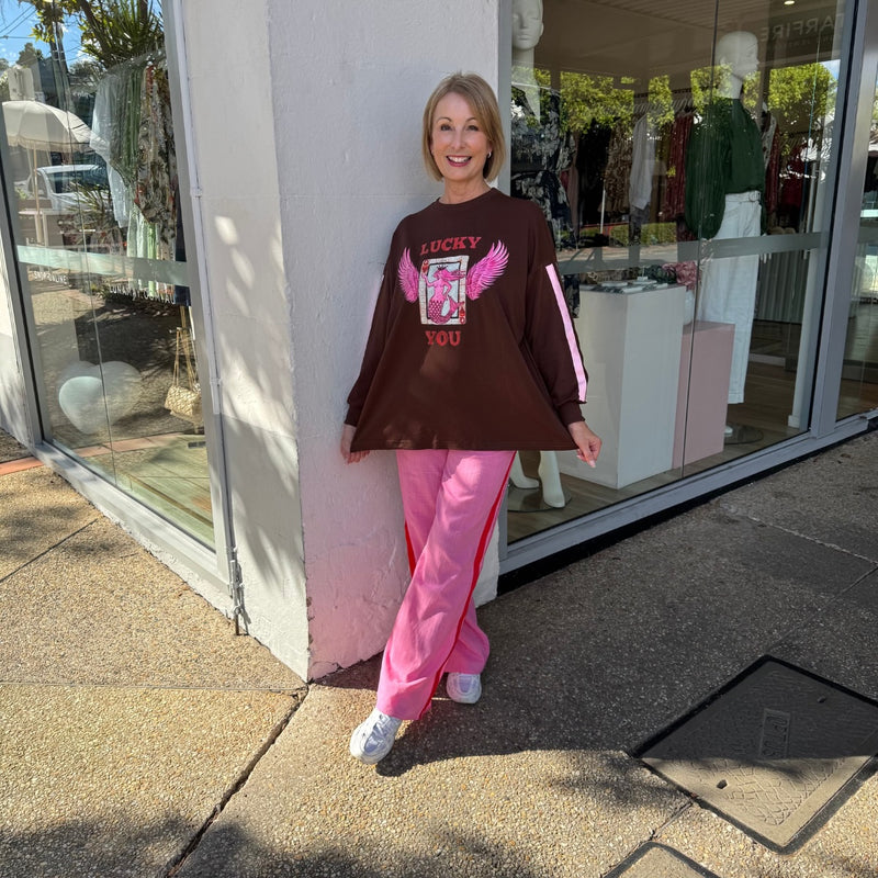 The top has a relaxed, oversized fit and it can be worn loose over the pants or tuck it in.