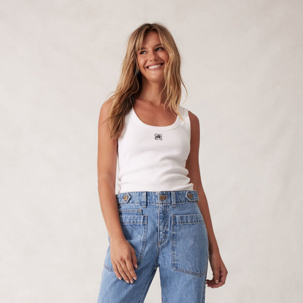 Our Zoe Contour Rib Tank in white with a black monogram logo on the front.