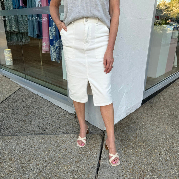 Sammi Denim Skirt in White. The skirt features button and zip closure, belt loops, deep front pockets, front split and it sits below the knee.