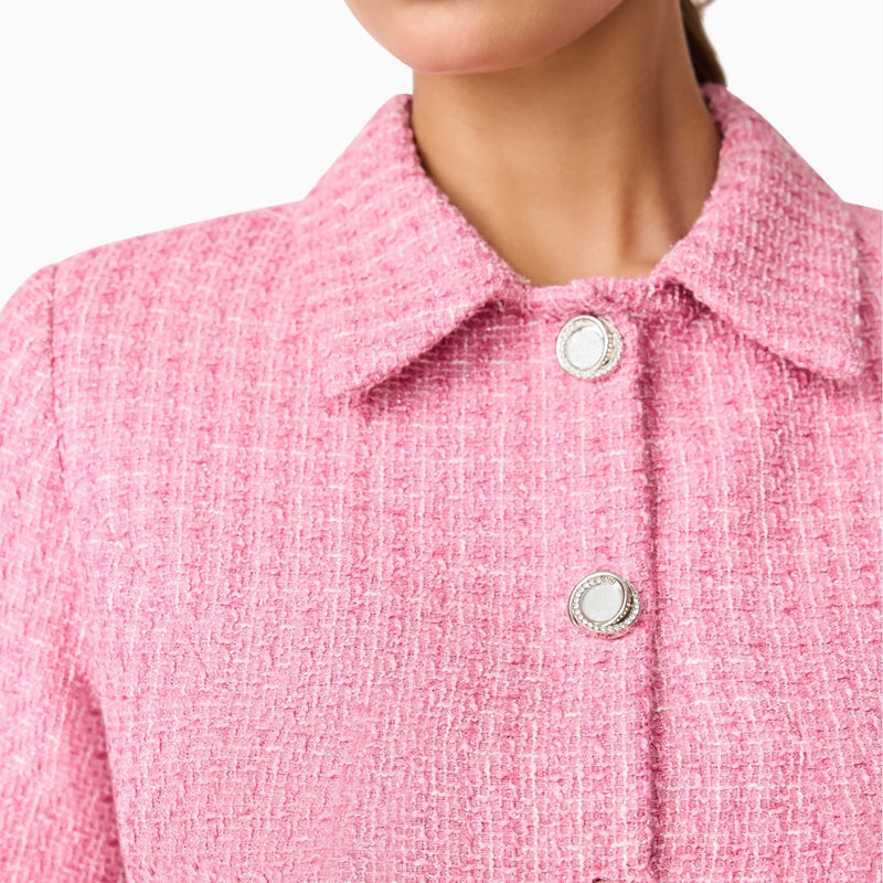 Close up of the pink tweed fabric which has small white flecks and a silver metallic thread.