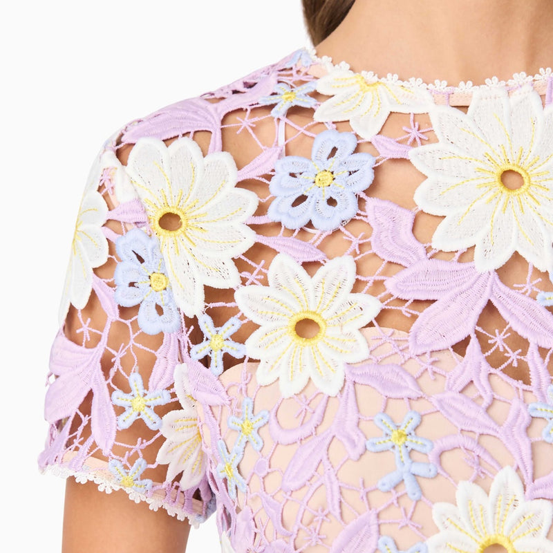 Close up of the beautiful fabric and the white crochet detailing around the neckline and sleeve edge.