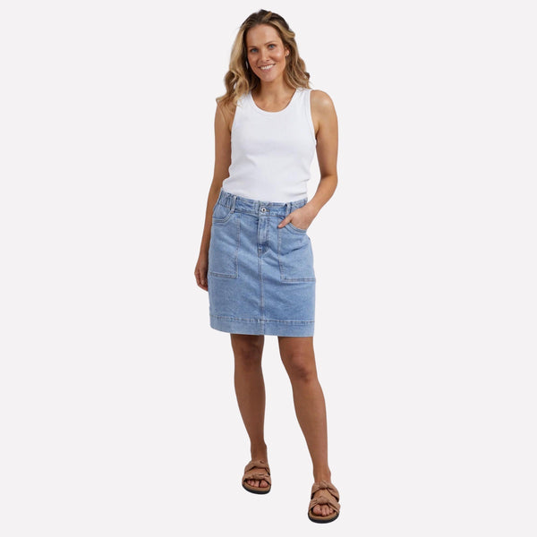 The Atlas Denim Skirt sits above the knee and has a button and zip closure