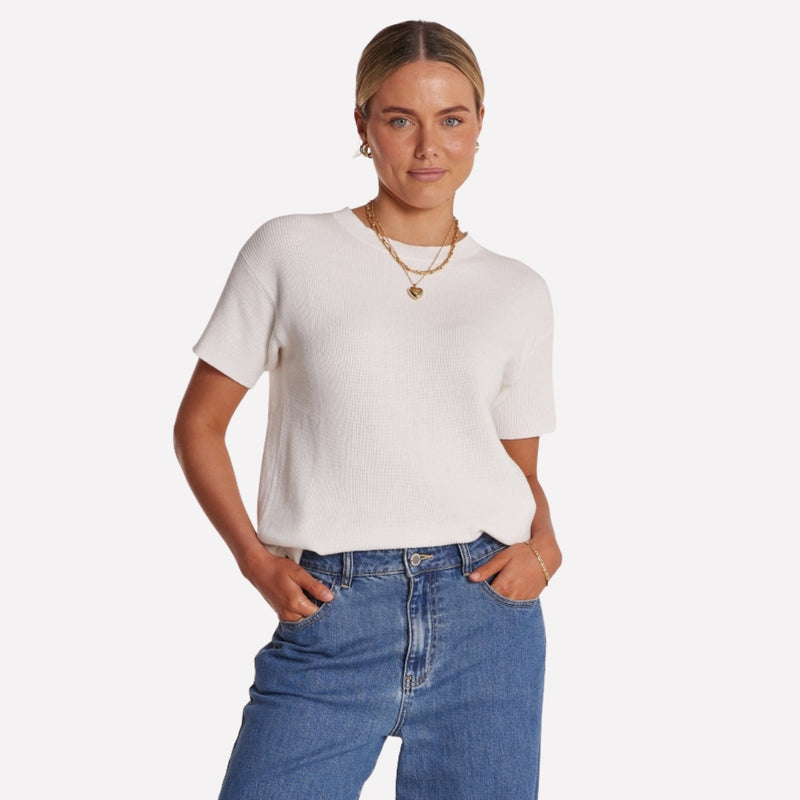 The top has a round neckline, drop shoulder and short sleeves.
