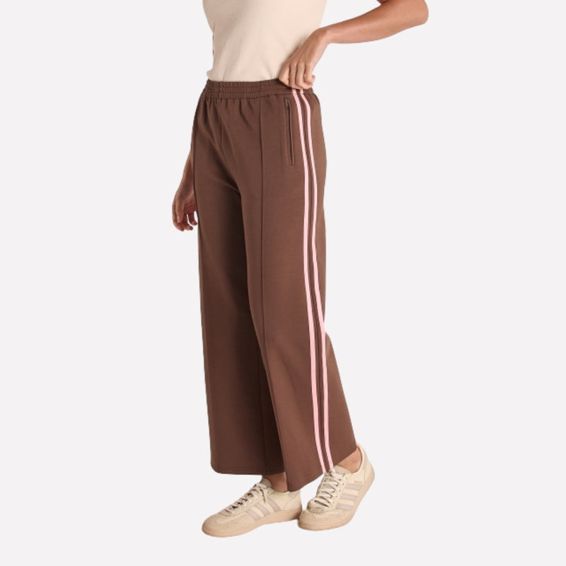 Side view of the pants showcasing the pink stripe and they also have pin tuck detailing down the centre of the leg.