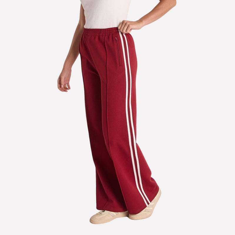 These pants have two white stripes on the outer side of the leg, an elastic waist, front zip pockets.