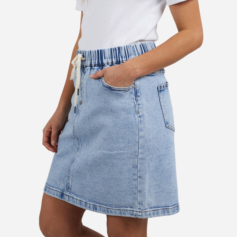 The skirt has an elasticated waist with white drawstring ties, front pockets and back pockets.