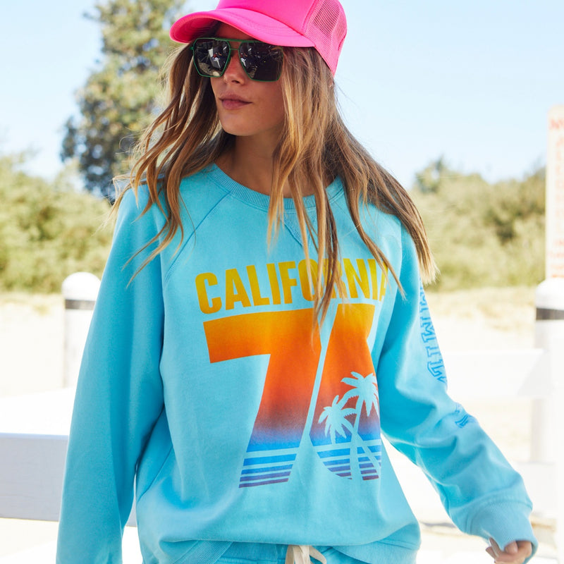 This aqua sweater has a colourful California 76 print on the front