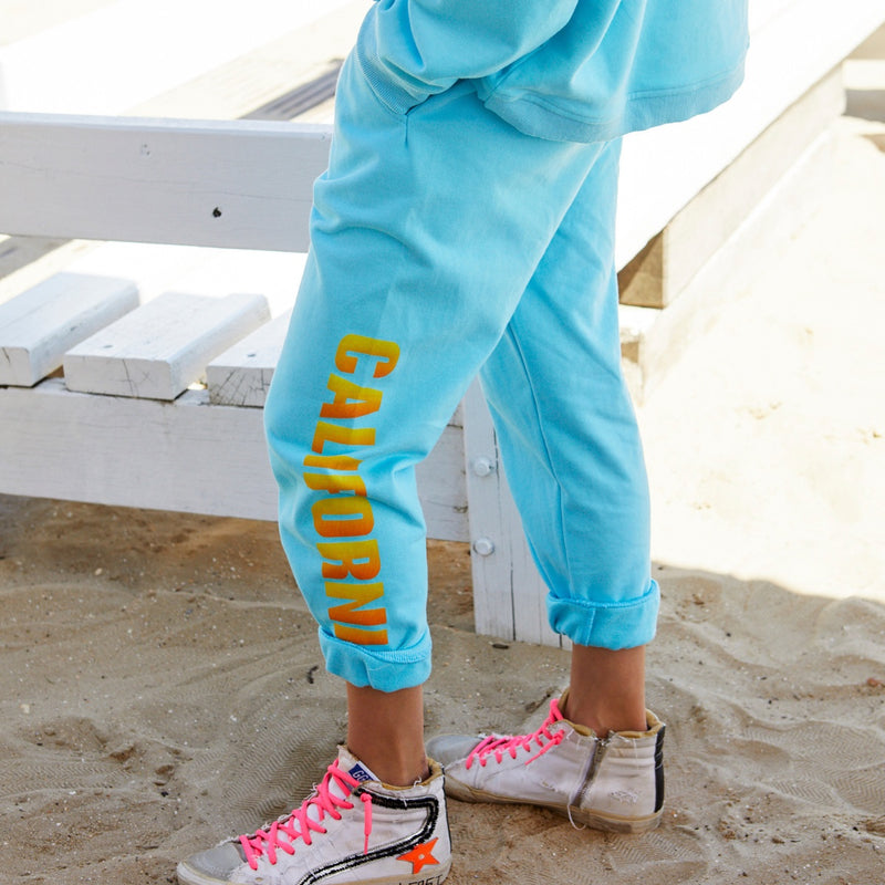 On the side of the left leg, these track pants have a multi coloured California print 