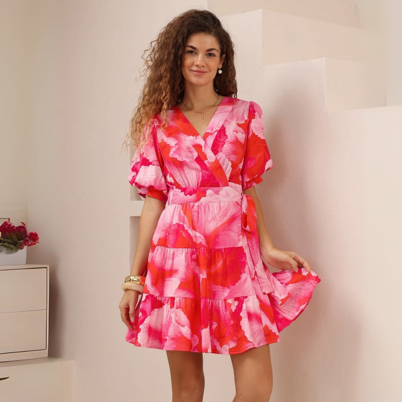 This traditional wrap style dress has a V neckline, short puff sleeves and a tiered short skirt.