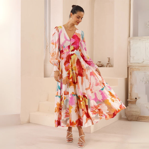 The dress features a V neckline, long sleeves with shirred cuffs and a flowing maxi length skirt.
